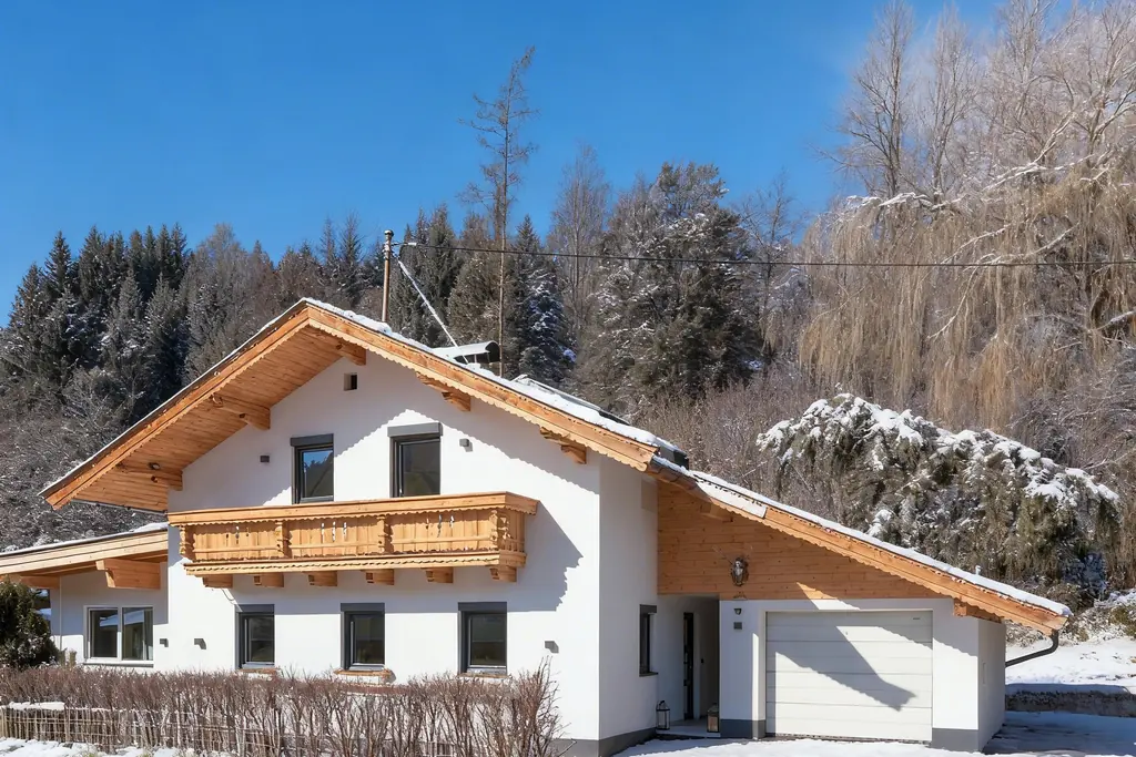 Het vrijstaande chalet in de sneeuw, met een houten gevelpunt, een gesneden balkon en een dennenbos erachter.